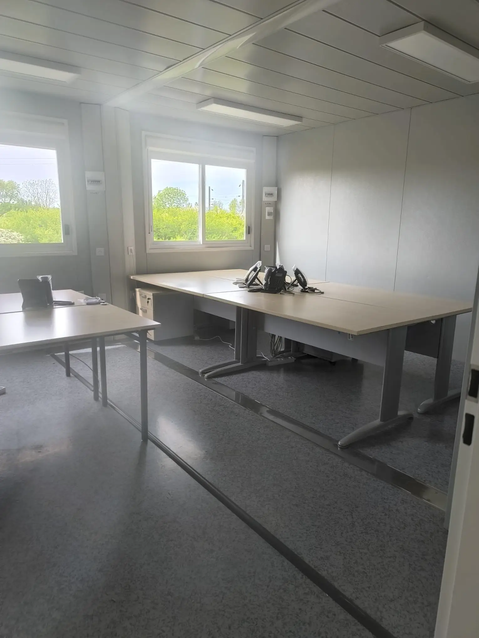 Bureaux modulaires neufs après nettoyage de fin de chantier : sol PVC, plans de travail et fenêtres nettoyés
