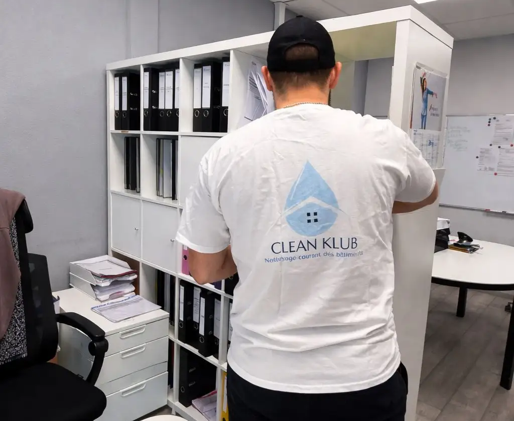 Agent CLEAN KLUB en tenue floquée, en intervention dans un bureau